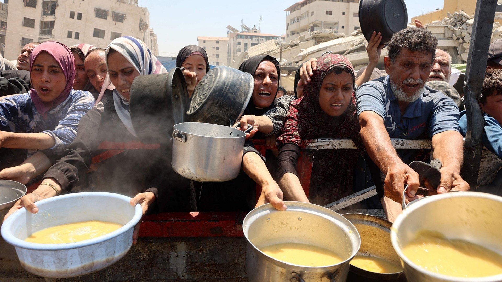 Palestinians crowd at a lentil soup distribution point in Gaza City in the northern Gaza Strip | Photo: Omar Al-Qatta/AFP